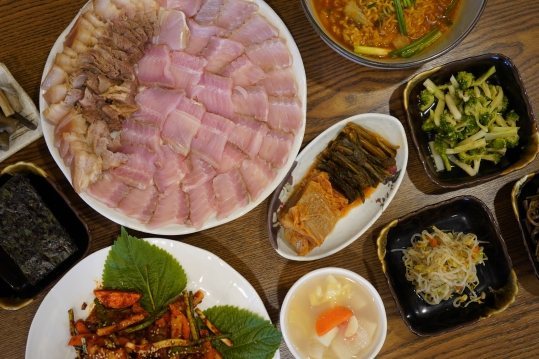 홍어 삼합 상차림 — 홍어·수육 접시와 무침, 김, 김치, 반찬